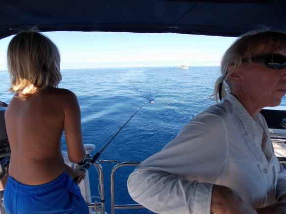 Logan taking his turn reeling the barracuda in while I sail.