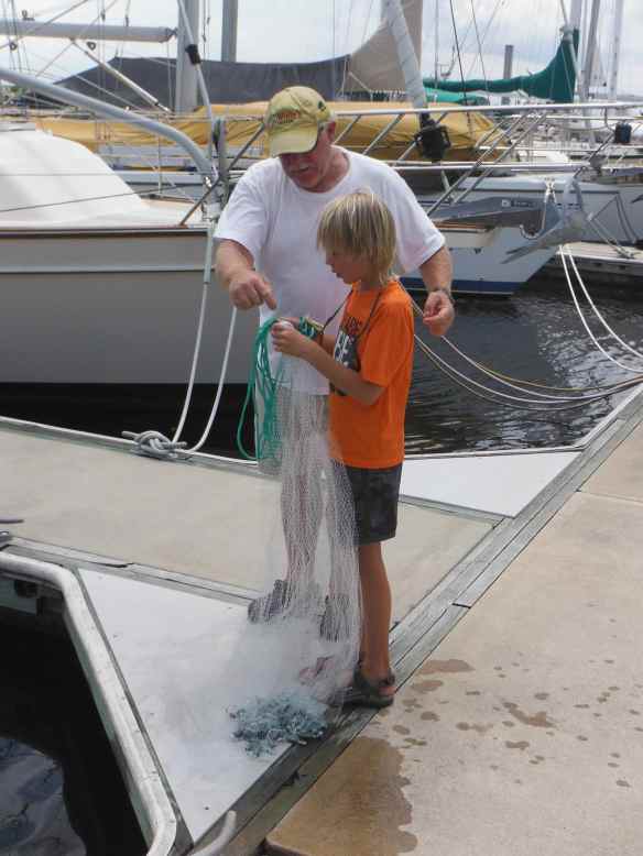 Jesse teaching Cole how to throw a cast net to catch bait.
